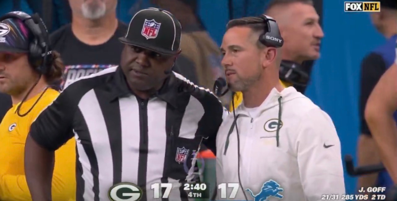 Matt LaFleur standing beside an NFL official during the Lions-Packers FOX broadcast